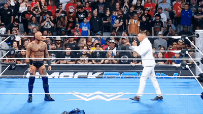 Man In White Suit In Wrestling Ring With Two Men GIF