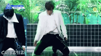 Man In White Suit Kneeling On Stage, Another Standing GIF