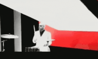 Man In White Suit Playing Drums GIF