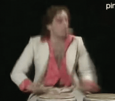Man In White Suit Playing Drums In Dark Room GIF
