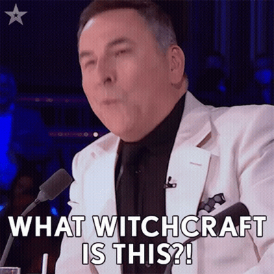 Man In White Suit Saying What Witchcraft Is This Into Microphone GIF