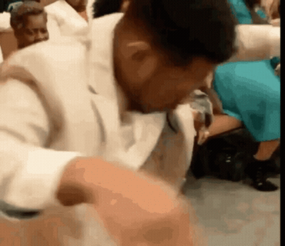 Man In White Suit Sitting In Church Crowd GIF