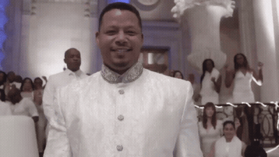 Man In White Suit Smiling In Front Of Group GIF