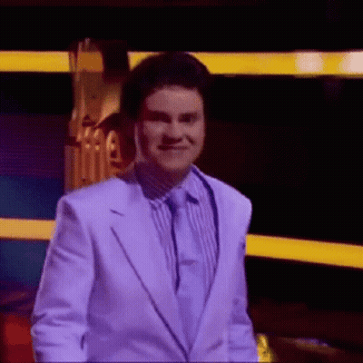 Man In White Suit Smiling In Front Of Stage GIF