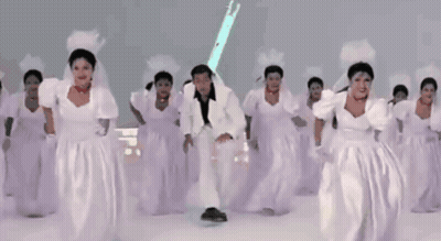Man In White Suit Surrounded By Bridesmaids GIF