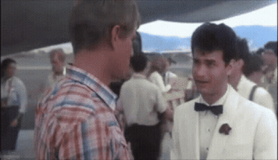 Man In White Suit Talking To Man In Plaid Shirt GIF