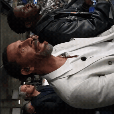 Man In White Suit With Microphone In Neck GIF