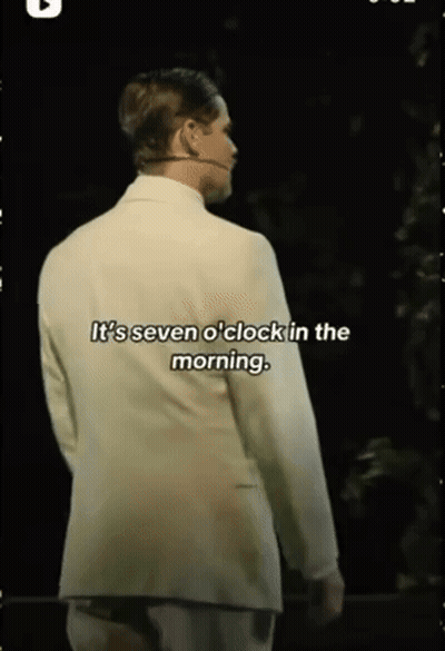 Man In White Suit With Microphone Says It's Seven O'Clock In The Morning GIF