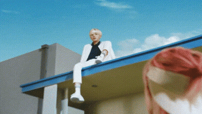 Man In White Suit With Pink-Haired Woman On Roof GIF