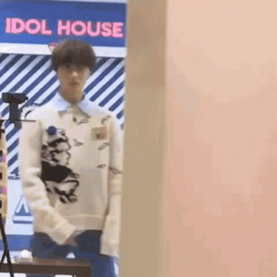 Man In White Sweater In Front Of Pink Wall GIF