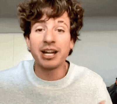 Man In White Sweater With Curly Hair And Tattoo Making Funny Face GIF