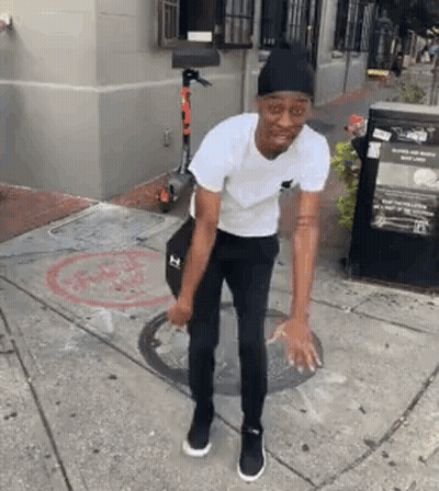 Man In White T-Shirt And Black Pants Standing Next To Scooter GIF
