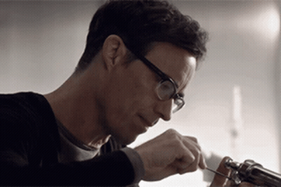 Man In White T-Shirt And Necklace Sitting By Window GIF