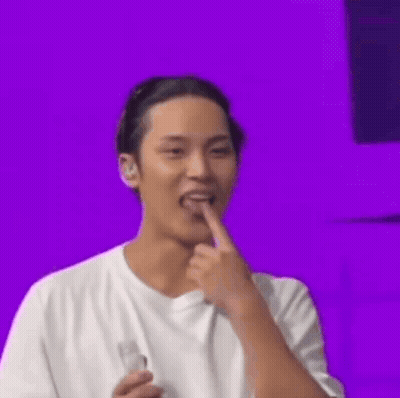 Man In White T-Shirt Holding Bottle And Licking Finger GIF
