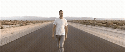 Man In White T-Shirt Walking Desert Road GIF