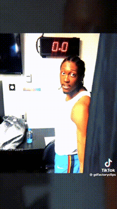 Man In White Tank Top And Blue Shorts In Front Of Clock Saying 0.0 GIF