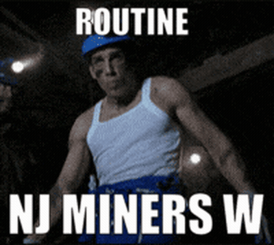 Man In White Tank Top And Blue Shorts In Front Of Routine NJ Miners Sign GIF