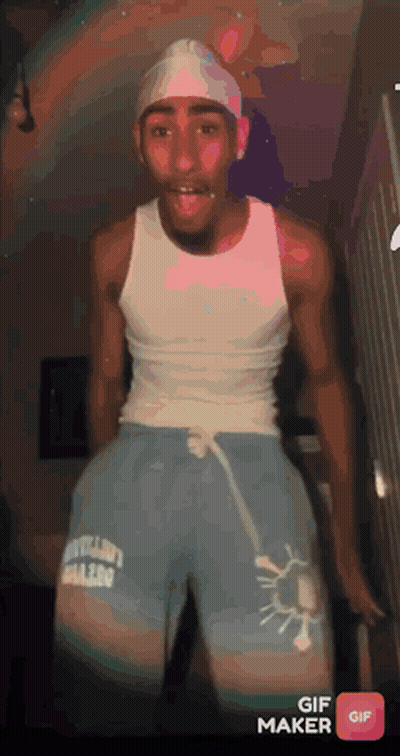 Man In White Tank Top And Blue Shorts Standing In Room GIF