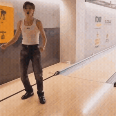 Man In White Tank Top And Jeans At Bowling Alley GIF