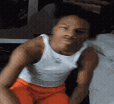 Man In White Tank Top And Orange Shorts Sitting On Chair GIF