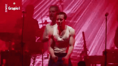 Man In White Tank Top Dancing Against Red Background GIF
