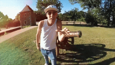Man In White Tank Top Holding Cannon GIF