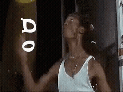 Man In White Tank Top Holding Frisbee In Front Of Do Sign GIF