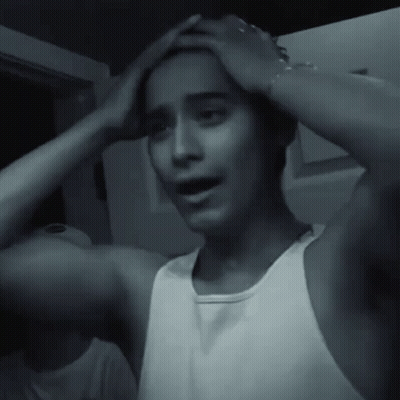 Man In White Tank Top Holding Head Black And White GIF