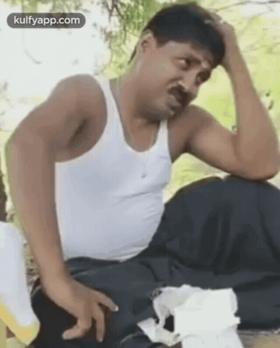 Man In White Tank Top Holding Head GIF