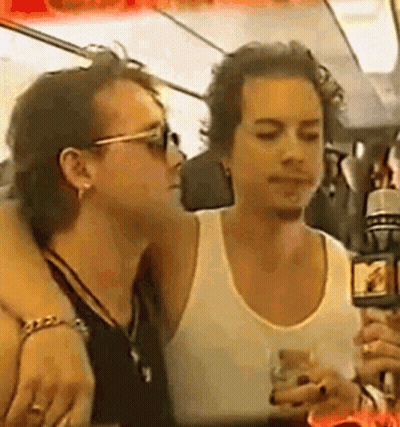 Man In White Tank Top Holding Microphone And Talking GIF