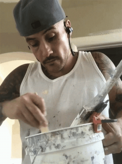 Man In White Tank Top Holding Paint Bucket GIF