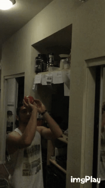 Man In White Tank Top Holding Red Apple GIF
