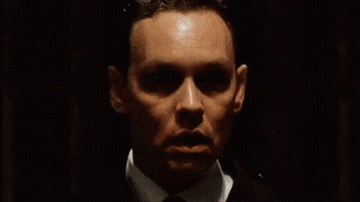 Man In White Tank Top In Dark Brick Room GIF