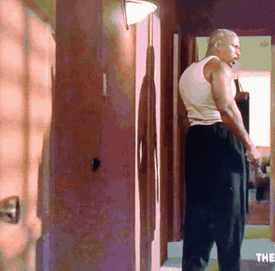 Man In White Tank Top In Hallway GIF
