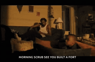 Man In White Tank Top Looking At Camera GIF