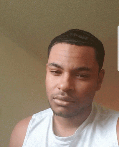 Man In White Tank Top Looking At Camera GIF