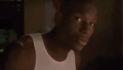 Man In White Tank Top Looking At Camera GIF