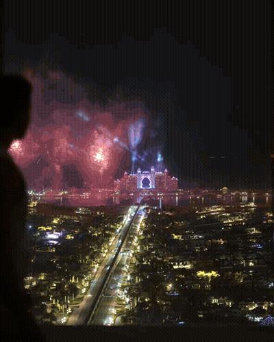 Man In White Tank Top Looking Over City At Night GIF