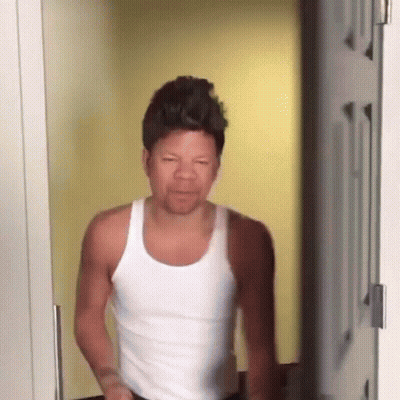 Man In White Tank Top Making Funny Face In Doorway GIF