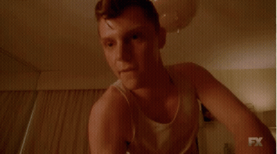 Man In White Tank Top Smiling In Dark Room GIF