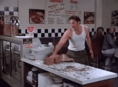 Man In White Tank Top Standing In Restaurant GIF