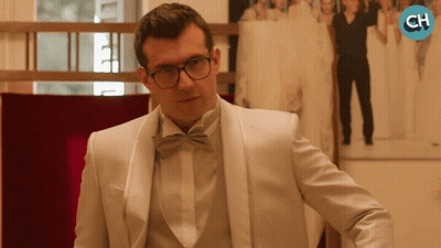 Man In White Tuxedo And Bow Tie In Front Of CH Logo GIF