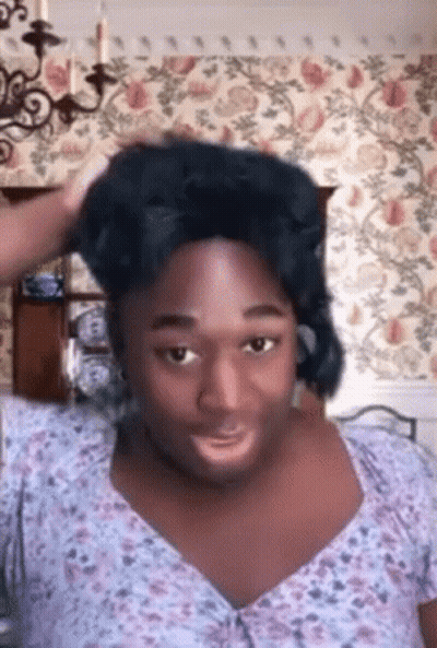Man In Wig And Floral Shirt Making Funny Face GIF