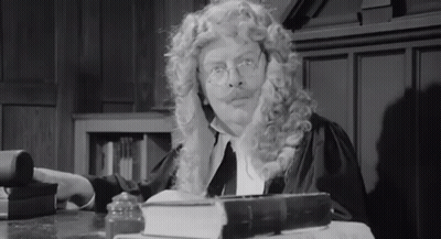 Man In Wig And Glasses At Desk With Book GIF