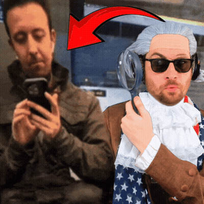 Man In Wig And Sunglasses Holding Magnifying Glass, Another Man On Phone GIF