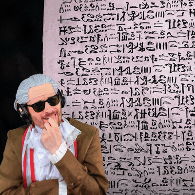 Man In Wig And Sunglasses In Front Of Arabic Writing GIF