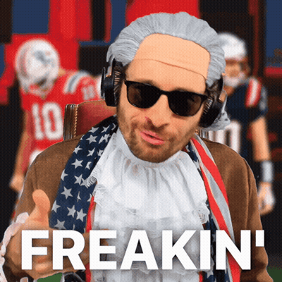 Man In Wig And Sunglasses Says Freakin In Front Of Football Players GIF