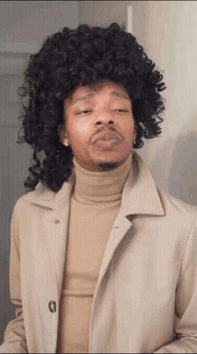 Man In Wig And Tan Trench Coat GIF