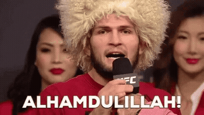 Man In Wig Holding Microphone Says Alhamdulillah GIF