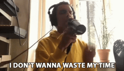 Man In Wig Standing In Front Of Sit Back And Relax Sign GIF